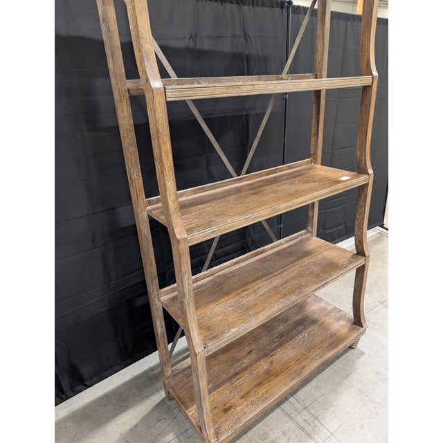 A well-crafted open étagère by Bassett, featuring a warm medium-to-dark wood finish with visible grain and subtle...