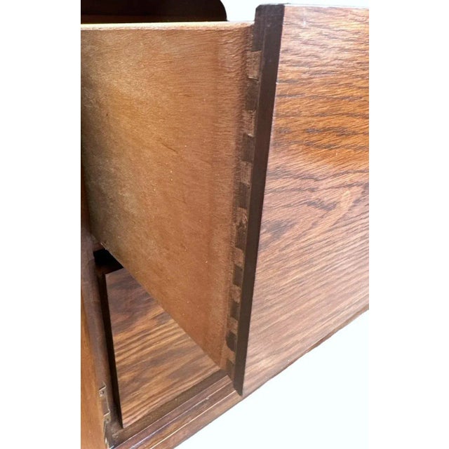 Dark finished oak with parquet details on center doors. Fine mid-century aesthetic. The design is very similar to work by...