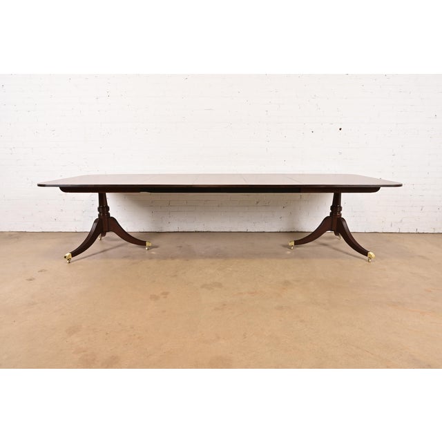 An exceptional Georgian or Regency style double pedestal extension dining table By Baker Furniture USA, Circa 1980s...