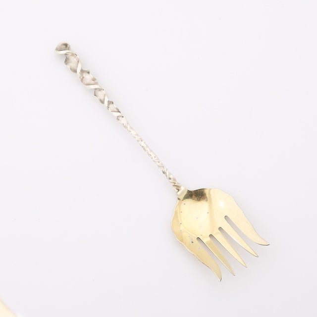 Crafted during the golden age of American design, this sterling silver and gold-washed square twist serving fork embodies...