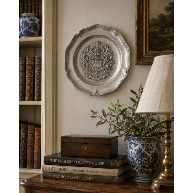 A handsome mid-20th-century French pewter wall plate by Les Etains du Prince, centered by the heraldic coat of arms of...