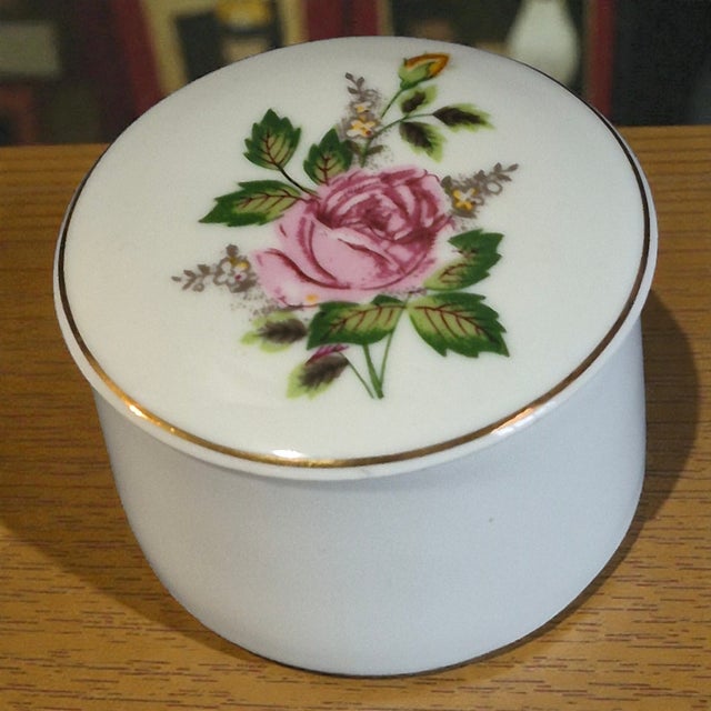 This Vintage Fine Porcelain Leart Brazil Romantic Pink Roses Trinket Box is a small round box adorned with a floral...