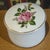 This Vintage Fine Porcelain Leart Brazil Romantic Pink Roses Trinket Box is a small round box adorned with a floral...