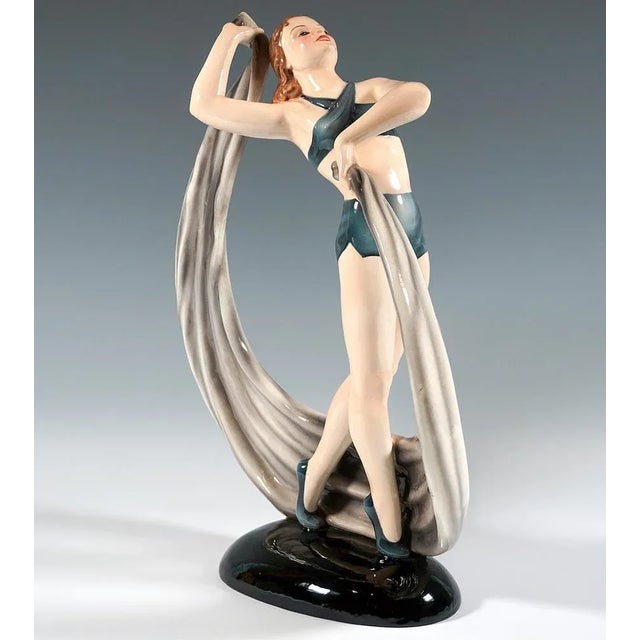 Girl with shoulder-length, brunette hair in a gymnastic suit consisting of short trousers and a tight bustier tied...