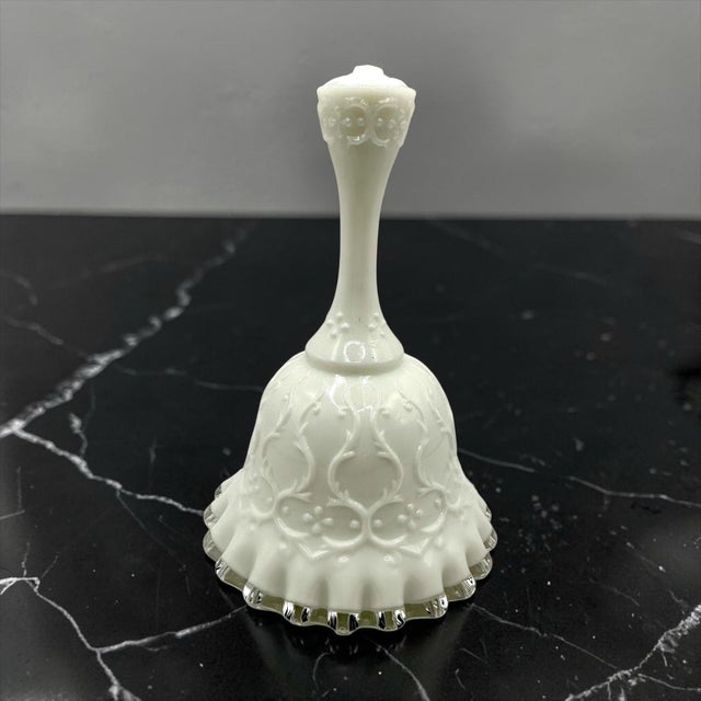 Crafted by the renowned Fenton Art Glass Company, this highly collectible bell features the intricate, raised "Spanish...