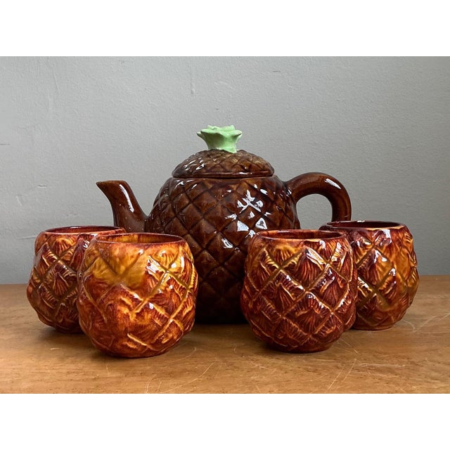Celebrate the playful spirit of mid-century entertaining with this charming vintage ceramic pineapple teapot and four mugs...