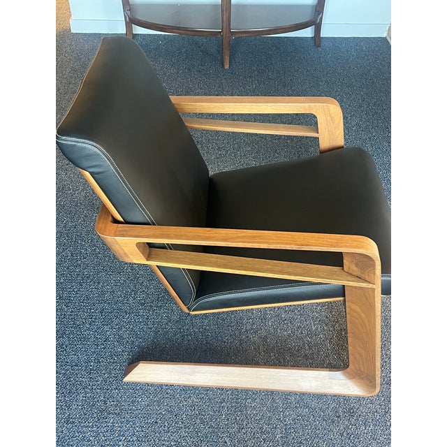 It is made of American walnut and Elmo leather. It reimagines the original 1953 Kem Webber “airline chair” that Walt...