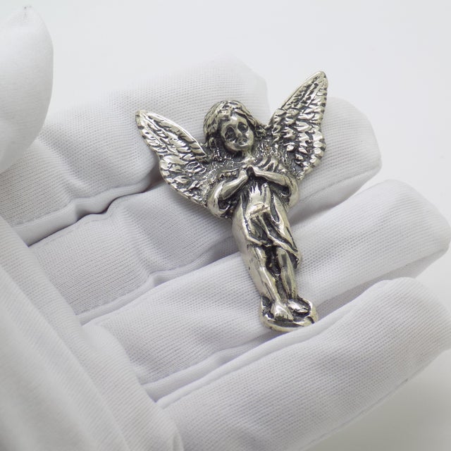 This vintage silver relief figurine depicts a guardian angel (angelo), designed with a reverse hook for wall hanging....