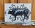 This oil painting presents a striking profile of a bull, rendered in rich, deep blacks that emphasize its muscular form...