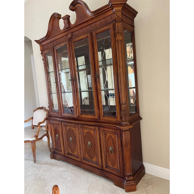 Traditional style China cabinet and hutch. Beautiful detail carving and lion ring handle accents. It has two glass shelves...