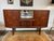 Danish modern solid teak sideboard or credenza with ample storage options. Features two sliding doors, which open to...