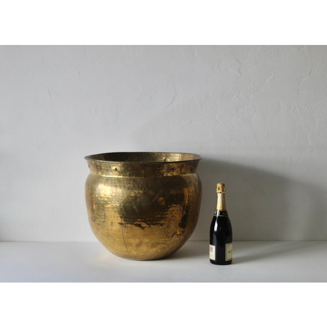 Hammered brass planter, cachepot or jardinière. Features a traditional rounded, pot-belly shape and a hammered textured...
