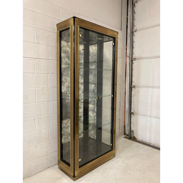 Offered is a vintage Mastercraft black lacquered, brass and glass display cabinet or vitrine. This beautiful cabinet...