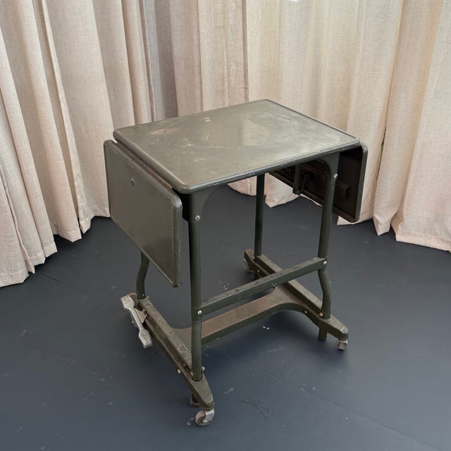 This industrial typewriter stand circa the 1940s showcases machine-age engineering with it's steel construction and...
