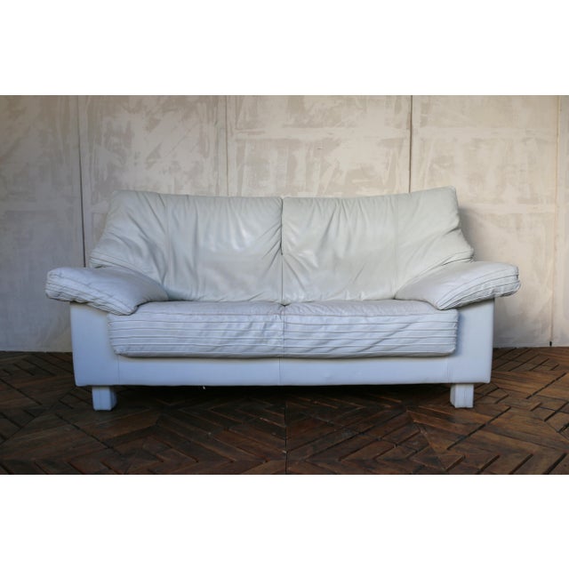 Beautiful Italian mid-century modern two-seat leather couch, circa 1980s. Upholstered in high-quality soft leather, this...