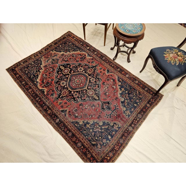 An early 20th century Persian Farahan Sarouk area rug in a classic medallion pattern of refined elegance. Hand-knotted...