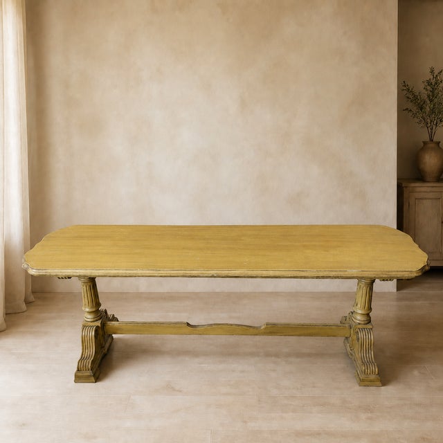 A striking long, low vintage sofa table in a softly timeworn butter-yellow painted finish. The rectangular top is...