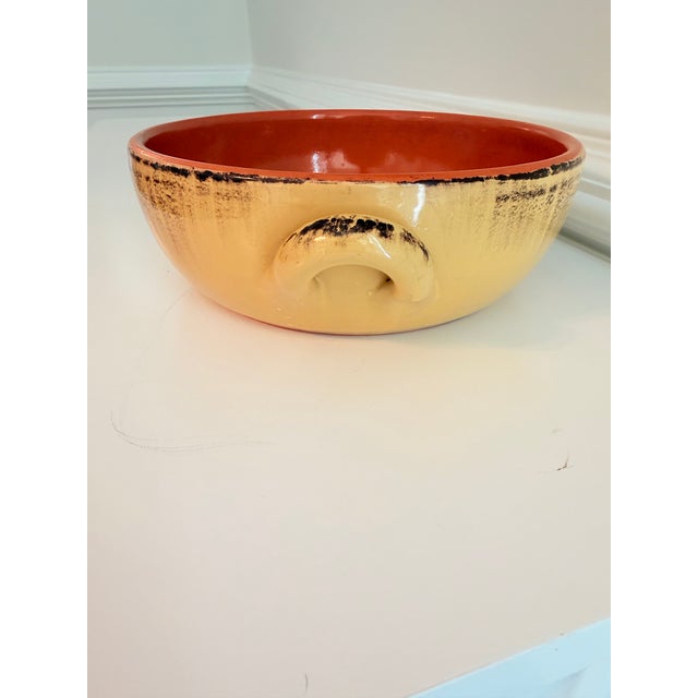 Handcrafted vintage ceramic centerpiece bowl featuring a warm ochre exterior with expressive dark brushwork and a striking...