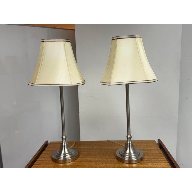 Design Plus Gallery presents a Pari of Silver Candlestick Table Lamps. These tall lamps are great as a duo for your...