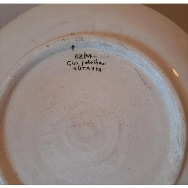 This is an oversized hand-painted ceramic wall plate from Turkey. It features a traditional floral motif with tiny stars...