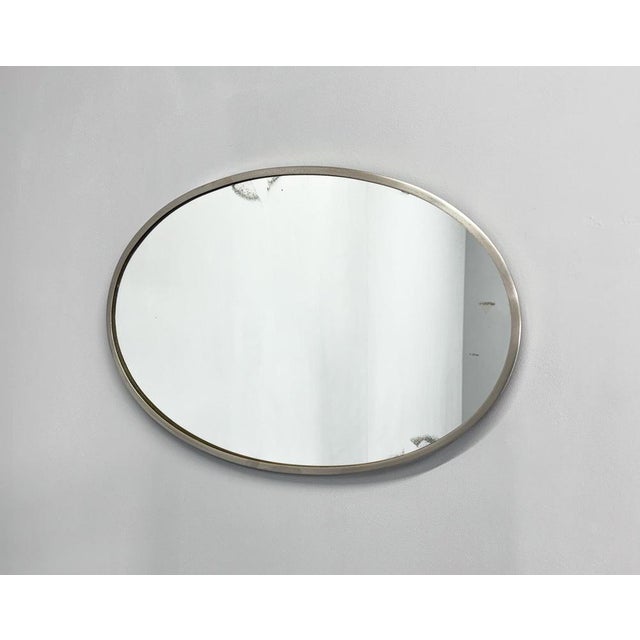 Mid-Century oval wall mirror in chromed metal frame. The back of the mirror is covered with original velvet. The mirror...