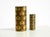 Two beautiful white glazed porcelain vases featuring black and gold geometric shapes resembling abstract peacock feathers....
