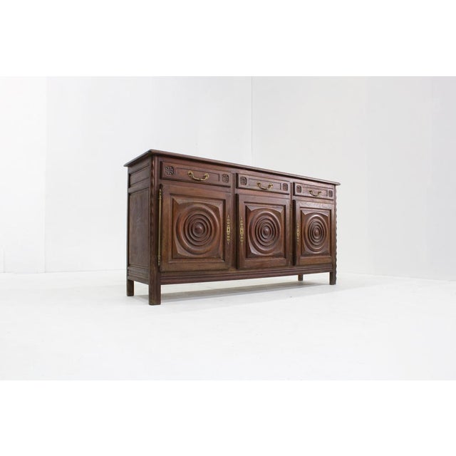 Vintage Carved solid Oak Sideboard in the style of Charles Dudouyt designed in the 1950s France. Large sideboard with...