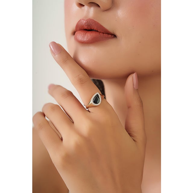 This cocktail ring features a 1.5 carat pear cut blue sapphire, set in 14K yellow gold, measuring approximately 5.4 x 8.8...