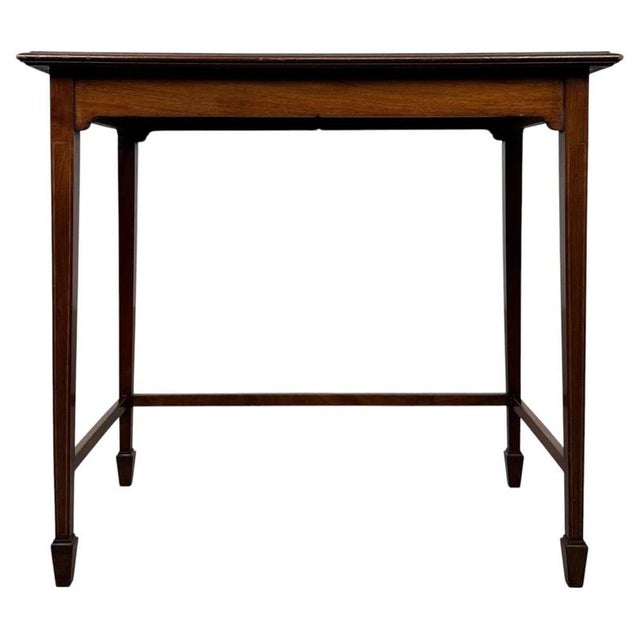 A beautifully crafted early 20th-century English Edwardian writing table, finely constructed in mahogany and distinguished...