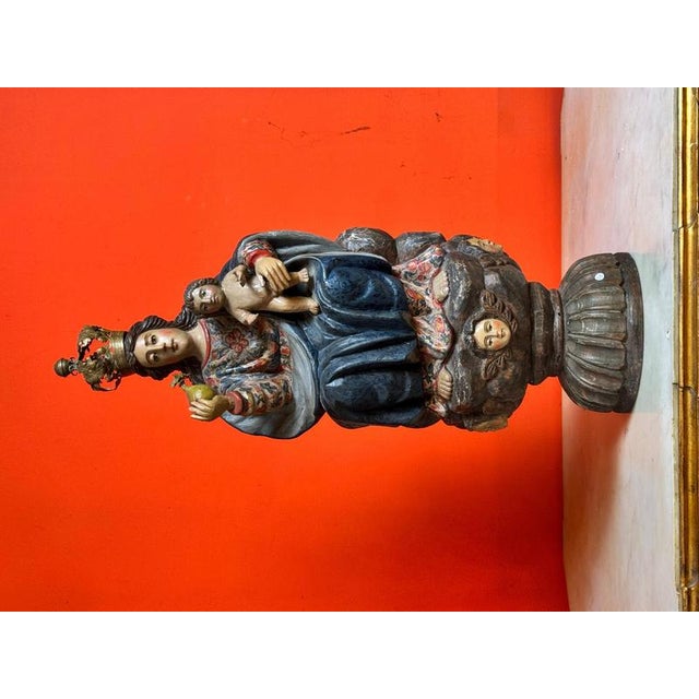 This devotional sculpture in carved wood, 61 cm in total height, depicts the Virgin enthroned with the Child Jesus,...