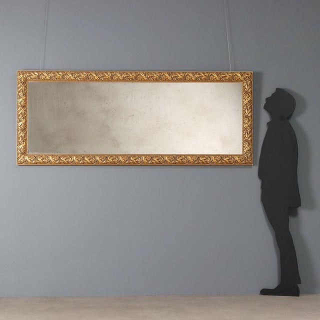 Large, gilded, carved frame with myrtle wreaths held in place by ribbon. The mirror is in late 20th-century style. This...