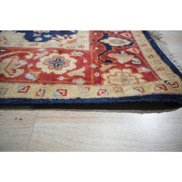 This blue wool rug features a hand knotted pile construction and measures 8 x 10 feet. Produced in India, this piece is an...