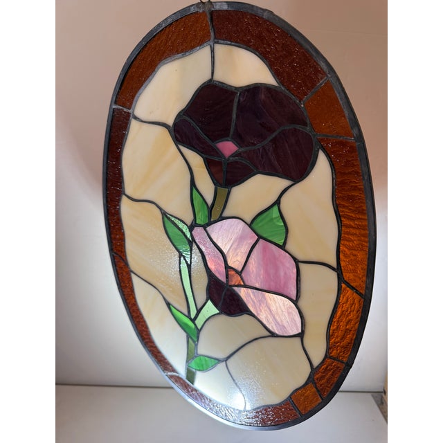 A beautiful oval-shaped stained glass panel measuring 13” x 18”, designed to bring vibrant color and warmth into any...