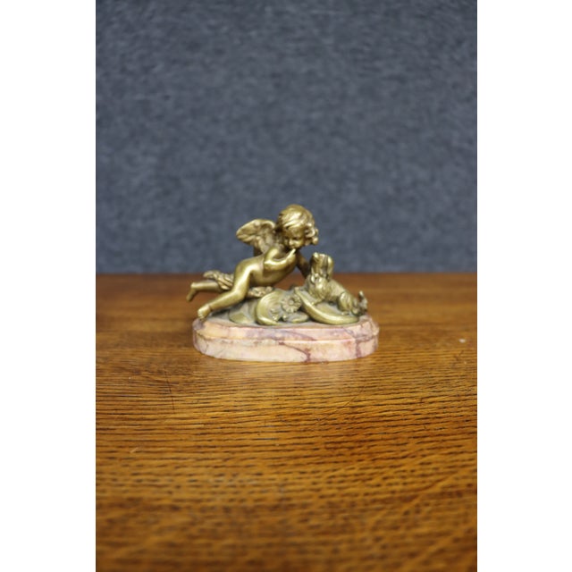 Fine 19th-century French bronze figure depicting a winged cherub reclining beside a small dog. The finely modeled cherub...