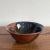 Red and blue glaze pop against black contrast on this eye-catching handmade decorative bowl. Interior features splashes of...
