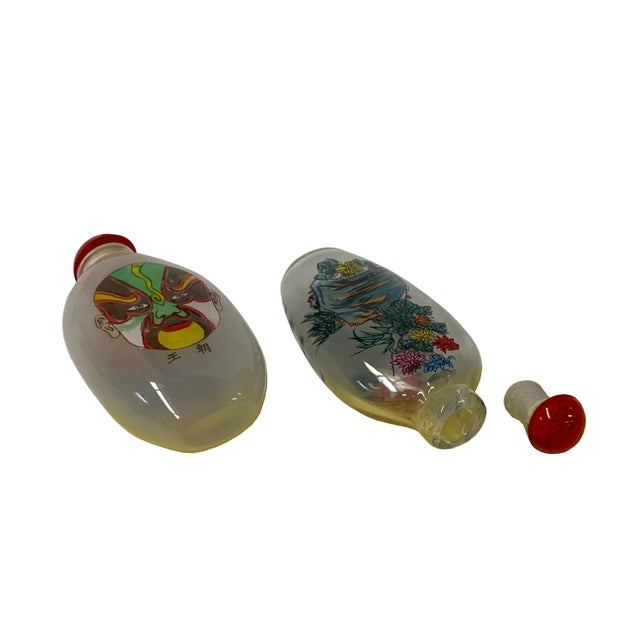 These two Chinese snuff bottles are made of glass, the surface is inside painted with oriental scenery graphics. Unique...