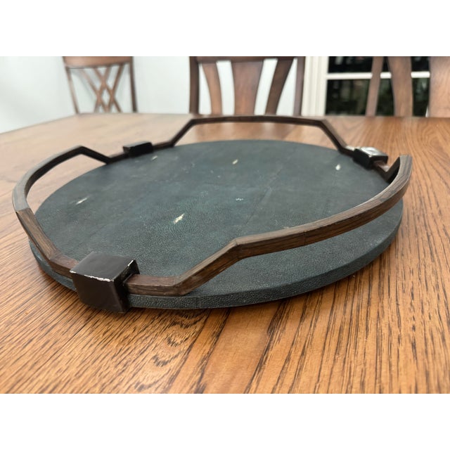 This is a luxury round decorative tray by R&Y Augousti featuring a textured shagreen surface framed by a sculptural dark...