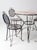 This is a mid 20th century vintage outdoor dining set. The wrought iron and mesh patio set includes a round table and four...