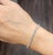 A modern platinum tennis bracelet featuring 55 round white natural diamonds totaling 4.89 carats, graded F/G color and...