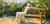Sun Worship by Linda Tracey Brandon | Oil Painting of a woman relaxing on a bench in sunlight For Sale