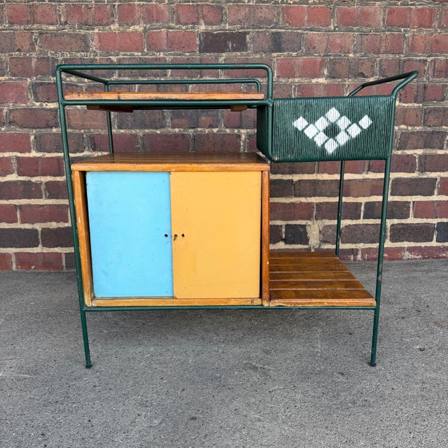 This is an amazing Arthur Umanoff outdoor bar cart. It has an iron frame, a rushed storage compartment, slatted wood...