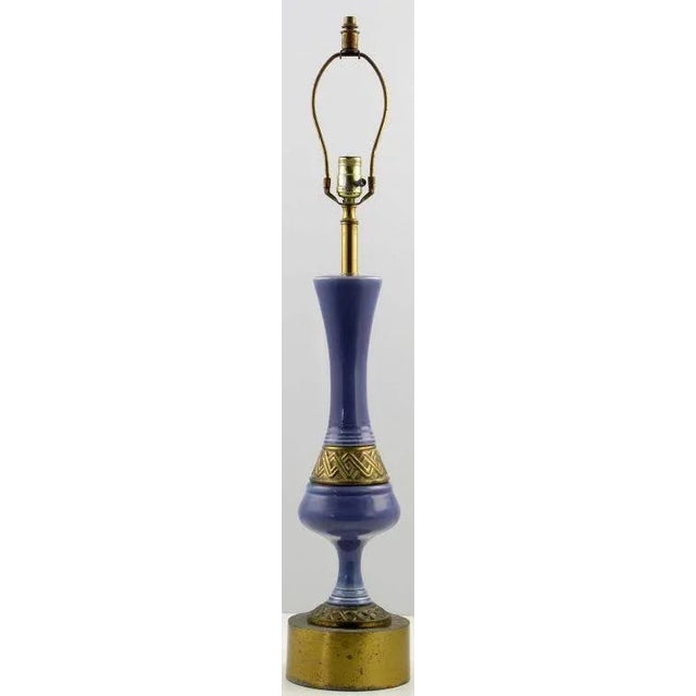 Statuesque table lamp,the body is a combination of brass and amethyst, leaning to periwinkle blue, glazed ceramic. The...