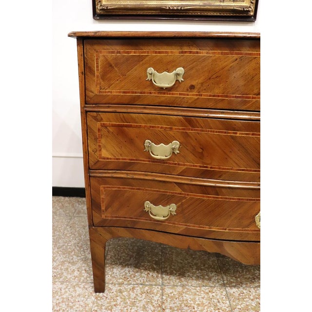 We present this elegant antique Italian chest of drawers dating back to the mid-18th century, Louis XV period. An...