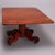 An antique American Empire table in the manner of Joseph Meeks offers mahogany construction with top having drop leaves...