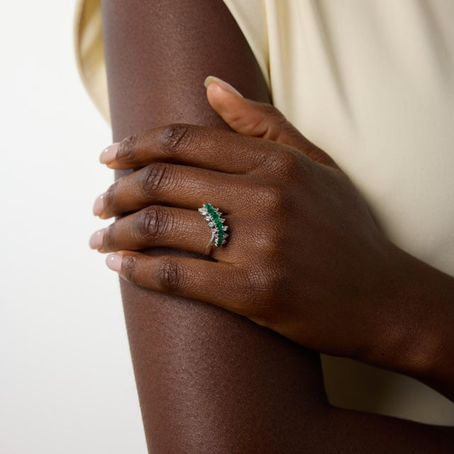 A graceful vintage ring that blends vivid color with refined brilliance, this elegant design features nine round cut...