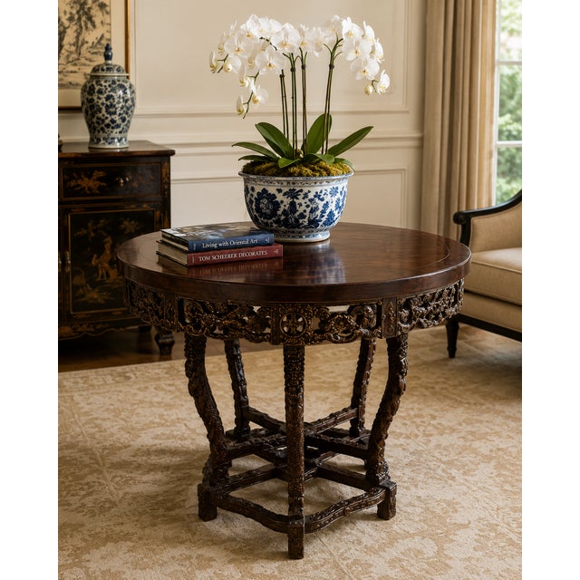 A striking Chinese Chippendale-style round center table featuring exceptional openwork carvings inspired by traditional...