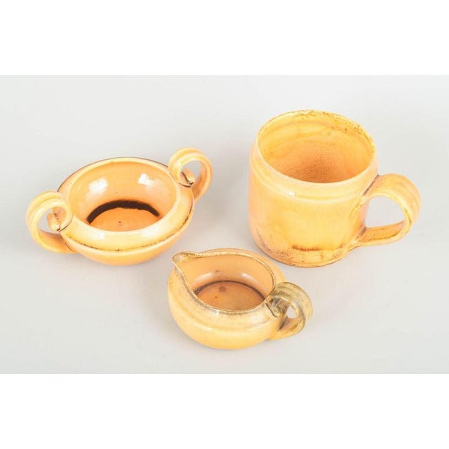 Kähler, Denmark Set with creamer, sugar bowl and mug, 1930s. Three pieces in the classic warm yellow-orange Kähler glaze...