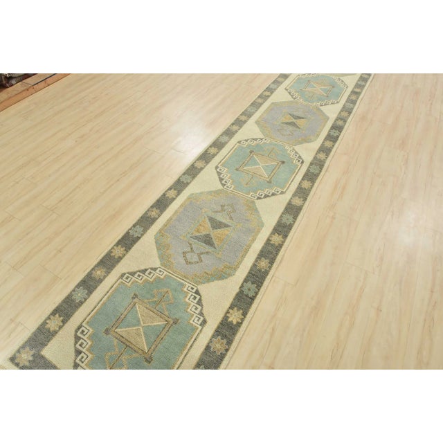 This tribal geometric Anatolia runner is hand-knotted with an all-wool pile on a cotton foundation. This rug is new and in...