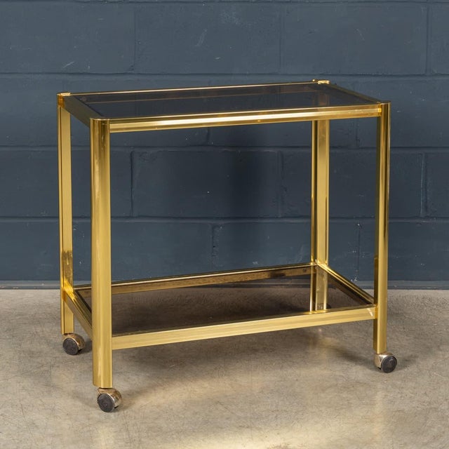 An elegant French drinks trolley dating from the 1970s, attributed to Maison Jansen. The refined rectangular frame is...