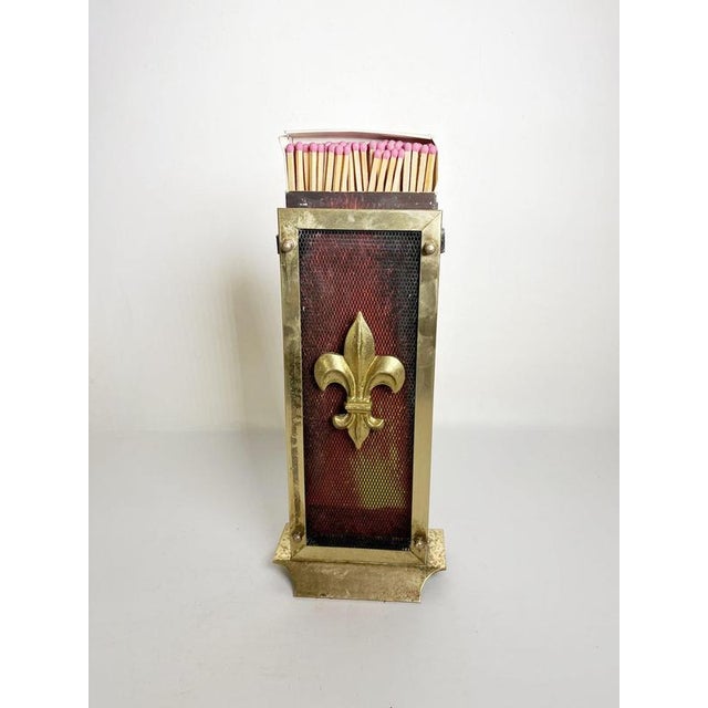 The matchbox is not included! French fireplace accessory dating from the 1950s, featuring a decorative brass-tone frame...